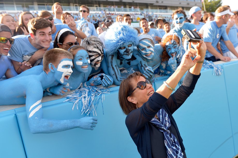 UNC Chancellor Carol Folt with fans at a football game.