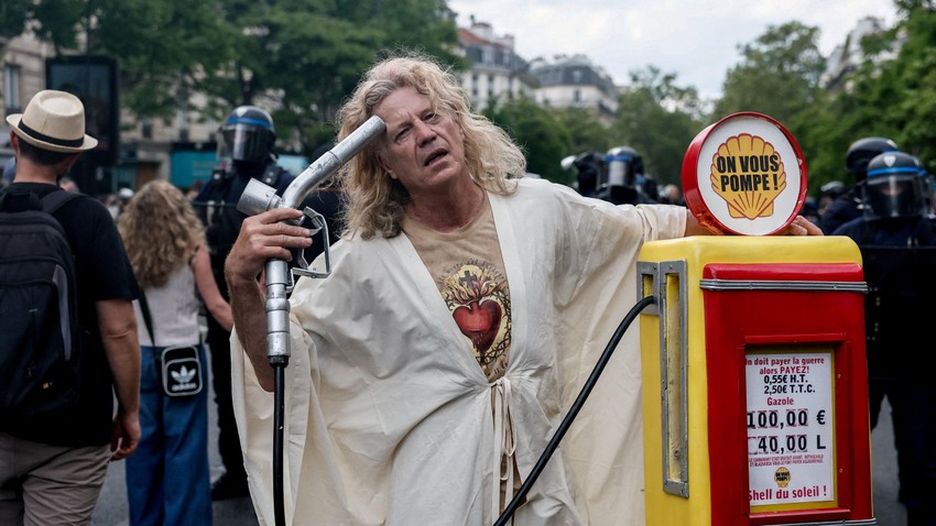 Muškarac sa maketom benzinske pumpe na ulicama Pariza | Foto: Reuters