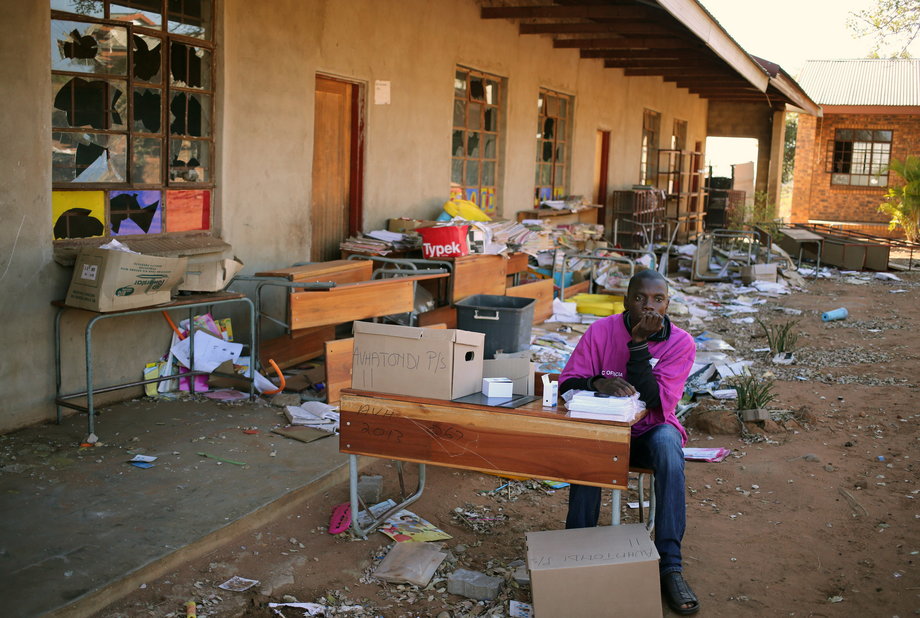 An IEC official waits for voters at a school which was damaged during riots in May, now used as a poling station during tense local municipal elections in Vuwani, South Africa's northern Limpopo province, August 3, 2016.