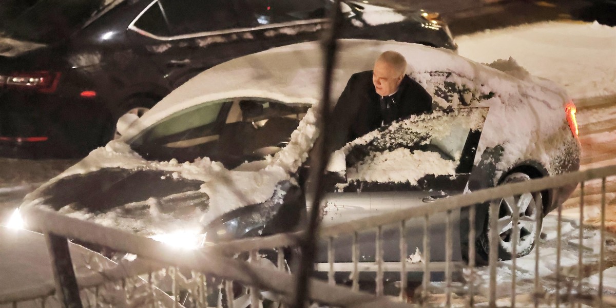 Jacek Sasin wsiada do nieodśnieżonego auta.