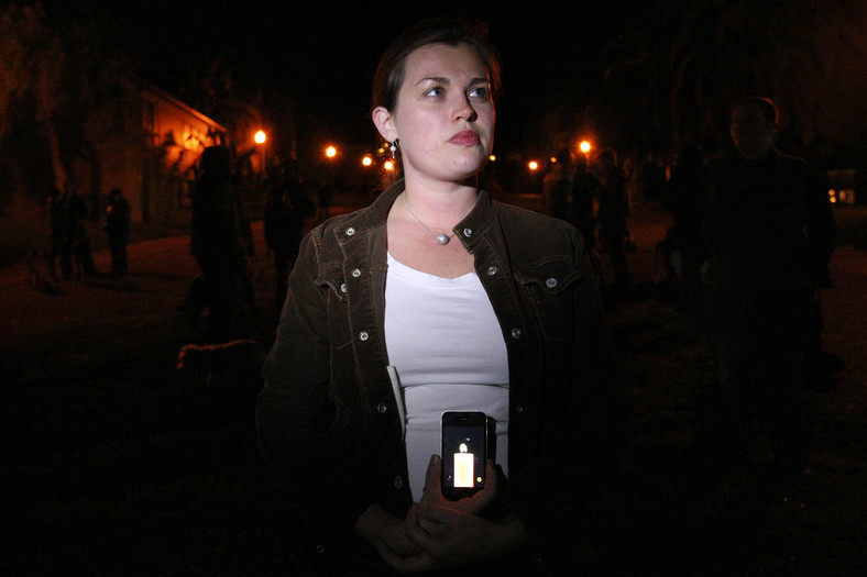 Hannah Roemhild wyświetla na iPhonie obrazek świecy, na część zmarłego Steobsa, San Francisco, fot. Erin Lubin/Bloomberg