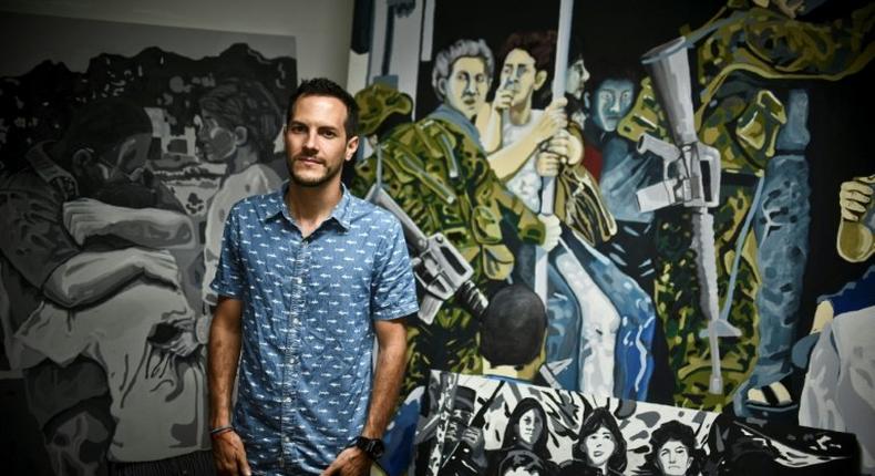 Colombian artist Juan Daniel Otoya, 28, poses beside his work in Cali, department of Valle del Cauca, Colombia, on January 12, 2017