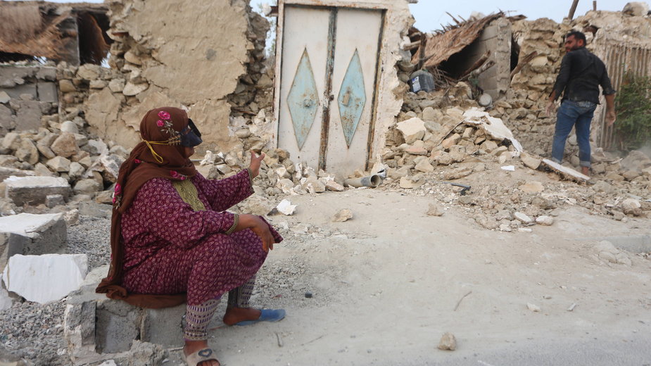 Kobieta siedzi przed gruzami swojego domu po trzęsieniu ziemi w wiosce Sayeh Khosh, w prowincji Hormozgan