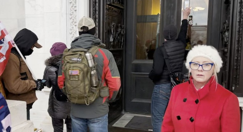 Dova Winegeart, at right, was photographed outside the window she's accused of striking with a stick.