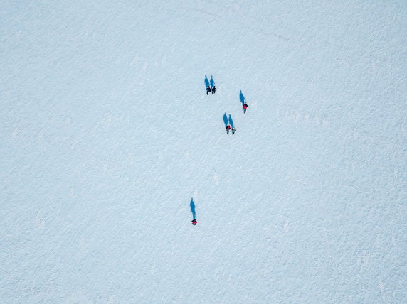 Naukowcy, przewodnicy i dziennikarze na niebieskim lodzie. Zdjęcie wykonano w 2022 roku podczas misji Instituto Antártico Chileno do Lodowca Union w Górach Ellswortha