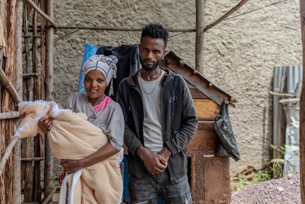 Feyara Daniel i Tirfesa Ayelu ze swym miesięcznym synkiem przed domem. Młode małżeństwo ledwie wiąże koniec z końcem, więc musi zapożyczać się na mleko dla dziecka