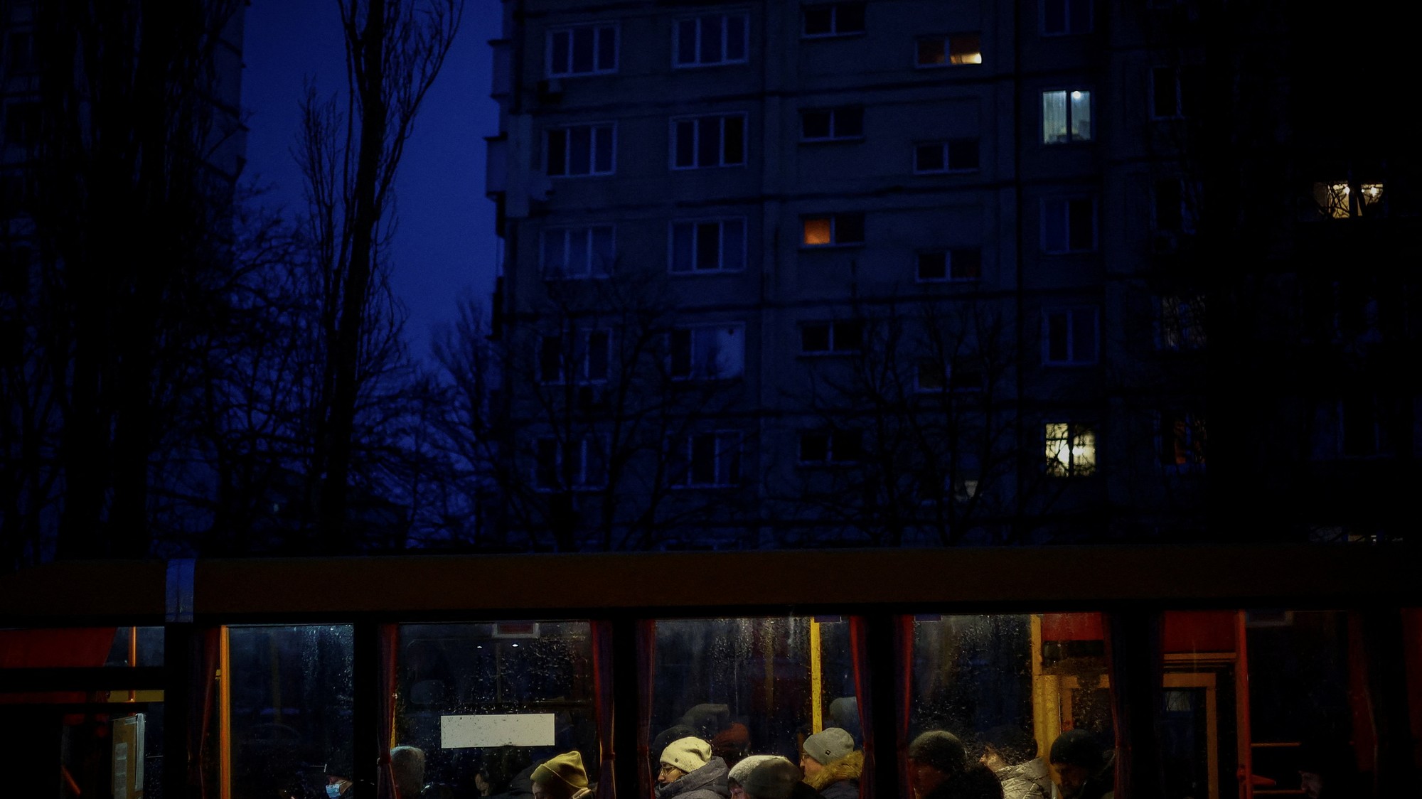 Obyvatelia Kyjeva sa po zotmení počas výpadkov elektriny spôsobených ruskými útokmi vezú autobusom.