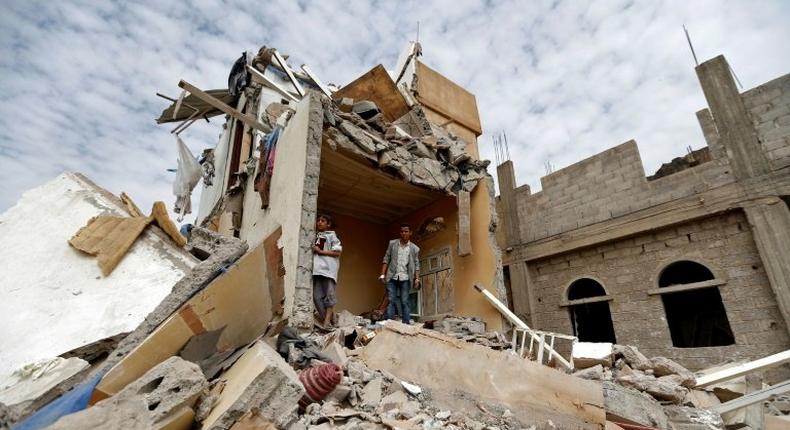 Yemenis stand in the rubble of a residential building destroyed in an air strike in the southern Faj Attan district of the capital, Sanaa, on August 25, 2017