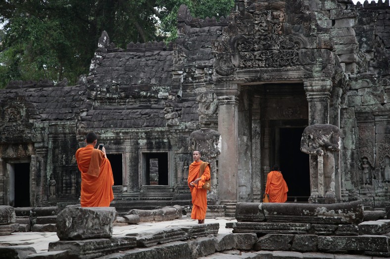 Buddyjscy mnisi robiący sobie nawzajem zdjęcia w świątyni w kompleksie Angkor