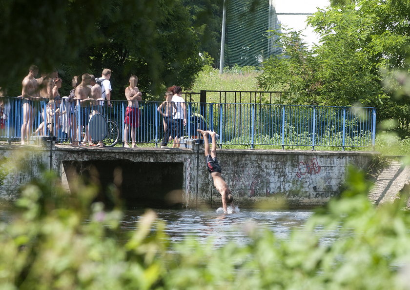 mężczyźni skaczą z mostu do wody