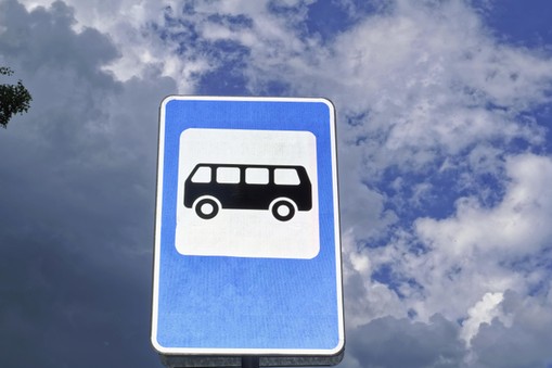 Bus stop road sign on background of blue sky.