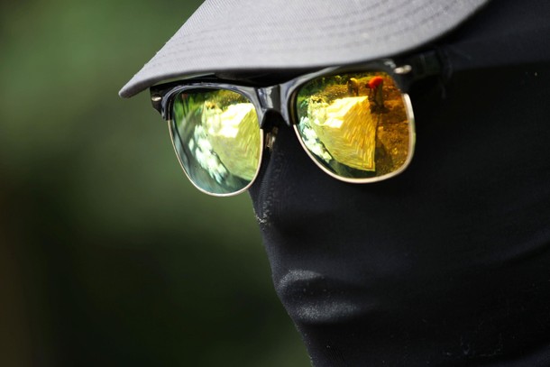 A soldier stands guard as workers moving packages containing cocaine and other substances for incine