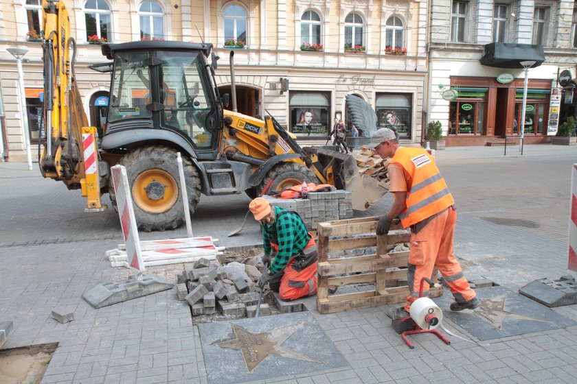 robotnicy zdejmują płyty na ulicy