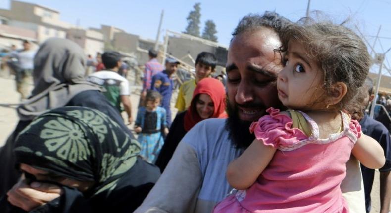 Displaced Iraqis evacuate their homes in western Mosul's Zanjili neighbourhood on June 1, 2017 during ongoing battles between Iraqi forces to retake the city from Islamic State group fighters