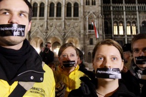 Hungarians, with stickers on their mouth, take part in a demonstration against the government's new 