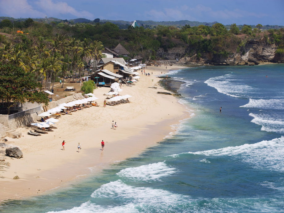 Balangan Beach in Bali, Indonesia, sits surrounded by rocky cliffs, while its shore includes an assortment of cafes serving a variety of Indonesian goods. The beach is popular among surfers, thanks to its impeccable weather and waves, and beginner surfers can take advantage of the several surf schools in the area.