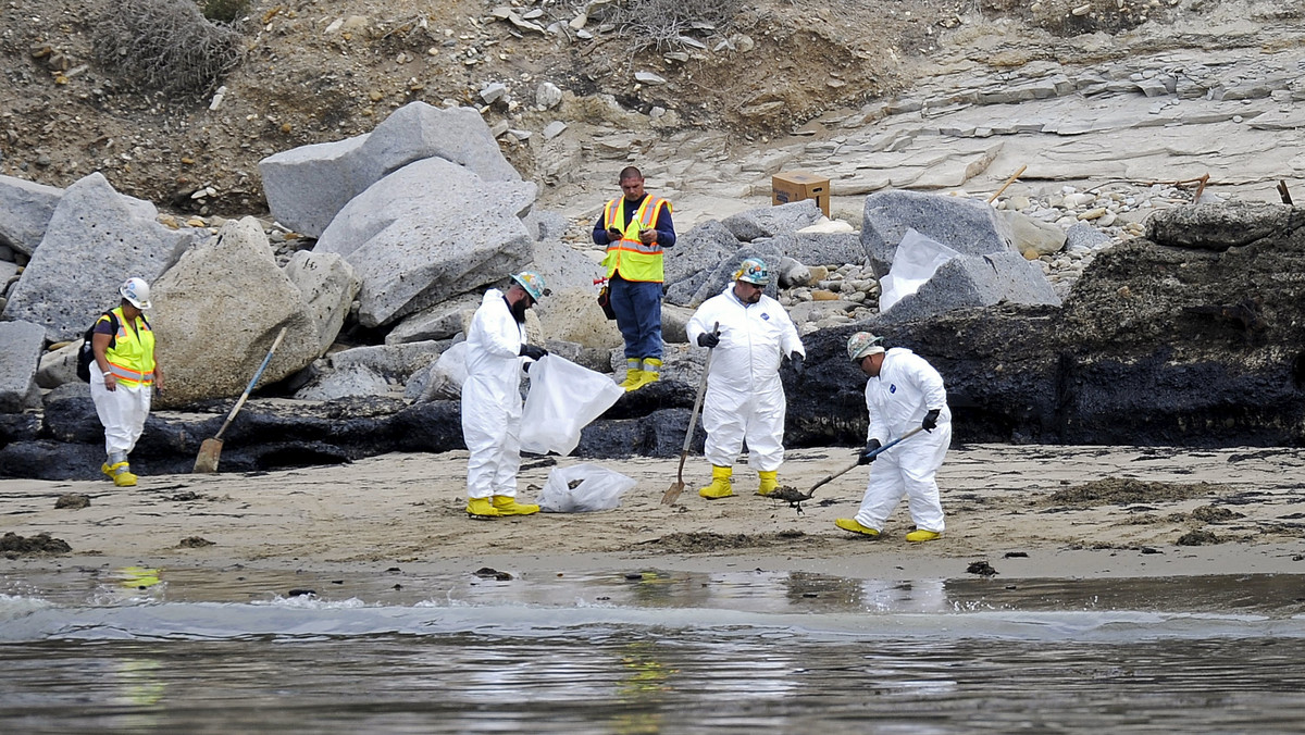 Crews clean the beach and oil covered rocks near Refugio State Beach on the Californian coast in Goleta