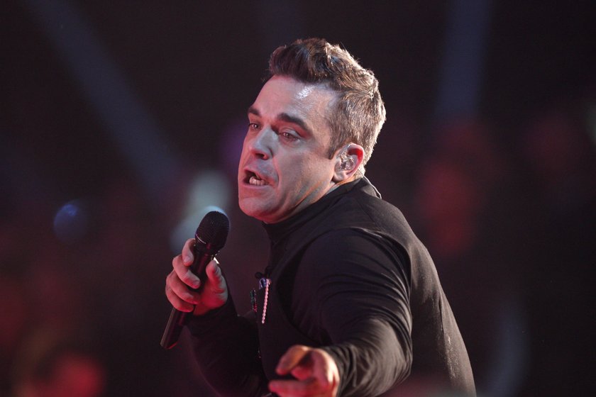 Robbie Williams na scenie z mikrofonem