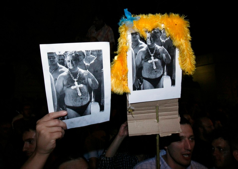 People hold images of Kaczynski, leader of the Law and Justice party, during clashes in Warsaw