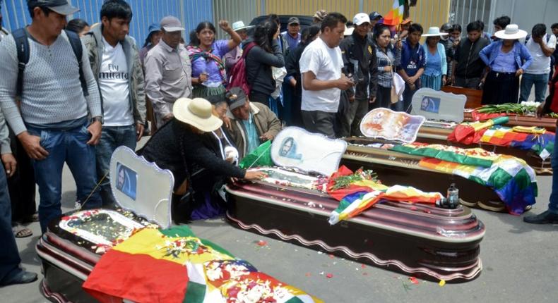 Relatives mourn by the coffins of protesters killed during protests in the Bolivian town of Sacaba on November 16, 2019