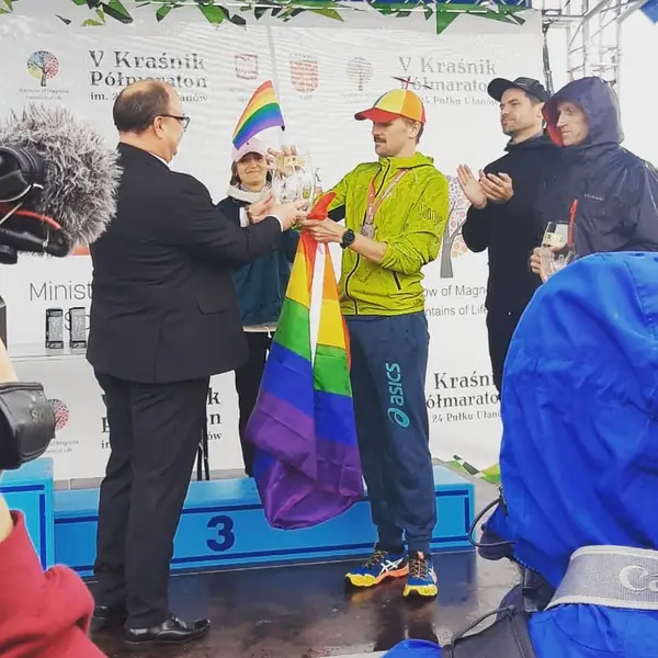 Kacper odbiera medal w Kraśniku z flagą LGBT