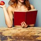 Naked woman reading and eating a peach