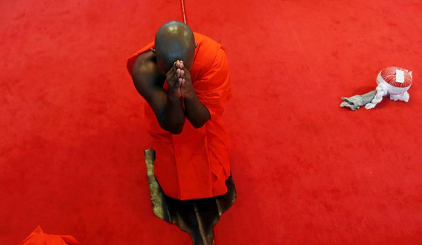 A newly ordained Buddhist monk prays during a ceremony of Upasampada, a Buddhist rite of higher ordi