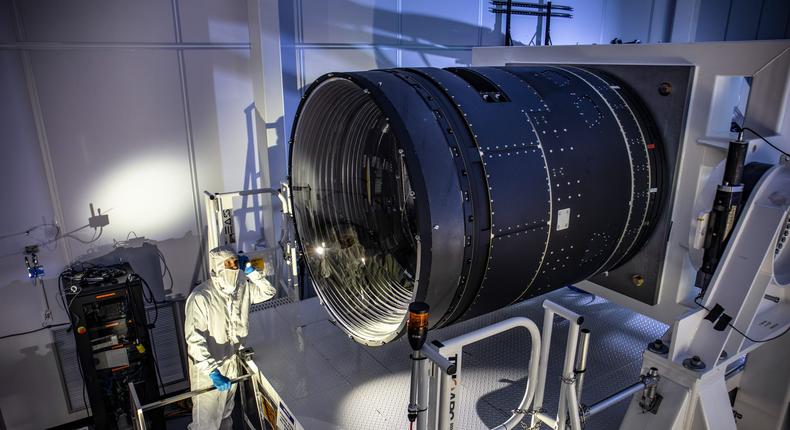 Deputy Project Manager Travis Lange shines a flashlight into the LSST Camera, which has a 5-foot-wide lens.Jacqueline Ramseyer Orrell/SLAC National Accelerator Laboratory