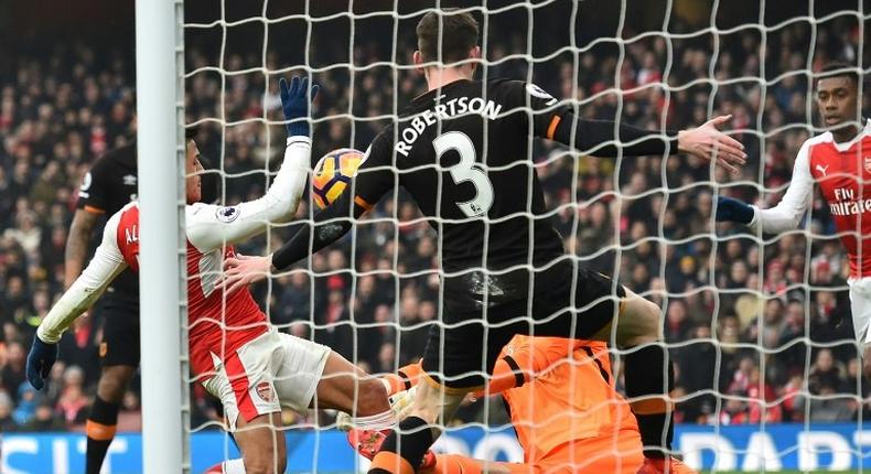 Arsenal striker Alexis Sanchez (L) scores the opening goal of his side's English Premier League match against Hull City at the Emirates Stadium in London on February 11, 2017