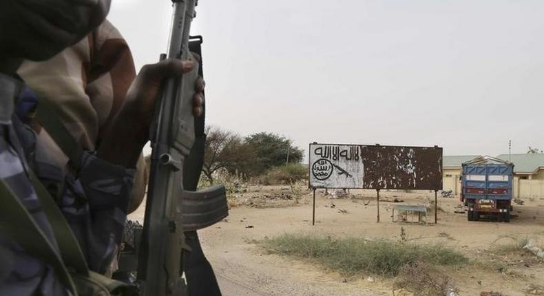 Chadian soldiers drive past a signpost painted by Boko Haram in the recently retaken town of Damasak, Nigeria, March 18, 2015. REUTERS/Emmanuel Braun