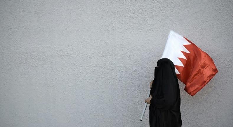 A woman holds the flag of Bahrain, a Shiite-majority Gulf kingdom