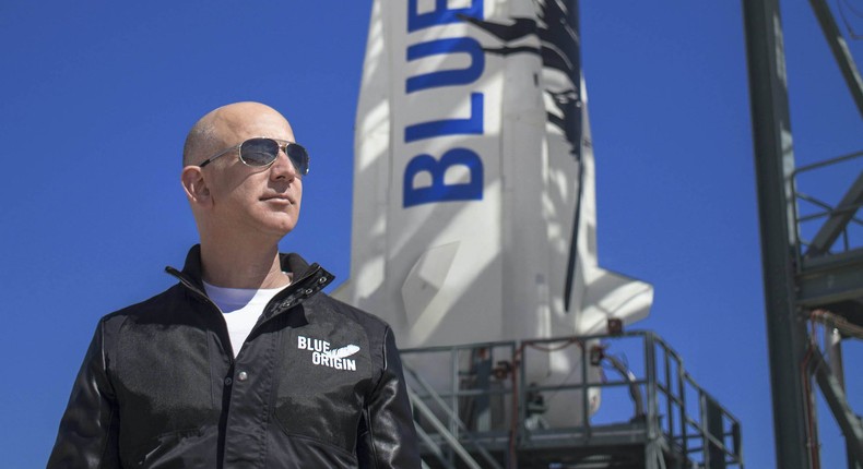 Amazon cofounder Jeff Bezos, next to a rocket created by his space company Blue Origin.
