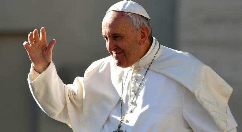 Pope Francis salutes people upon arrival in St. Peter's square at the Vatican for his weekly general audience on March 29, 2017