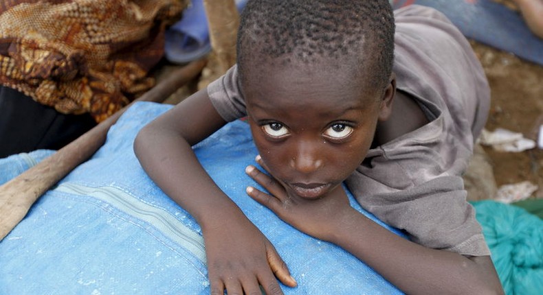 A Burundian refugee child rests on their belongings on the shores of Lake Tanganyika in Kagunga village in Kigoma region in western Tanzania, as they wait for MV Liemba to transport them to Kigoma township, May 18, 2015. REUTERS/Thomas Mukoya