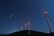 A meteor streaks across the sky during the Perseid meteor shower at a windmill farm near Bogdanci