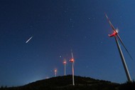 A meteor streaks across the sky during the Perseid meteor shower at a windmill farm near Bogdanci