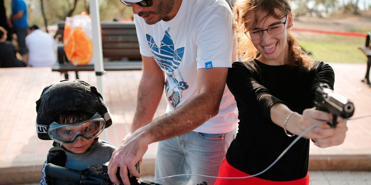 People playing with firearms during an "open day," exhibiting various policing skills and equipment to the public, in the southern Israeli city of Ashdod.