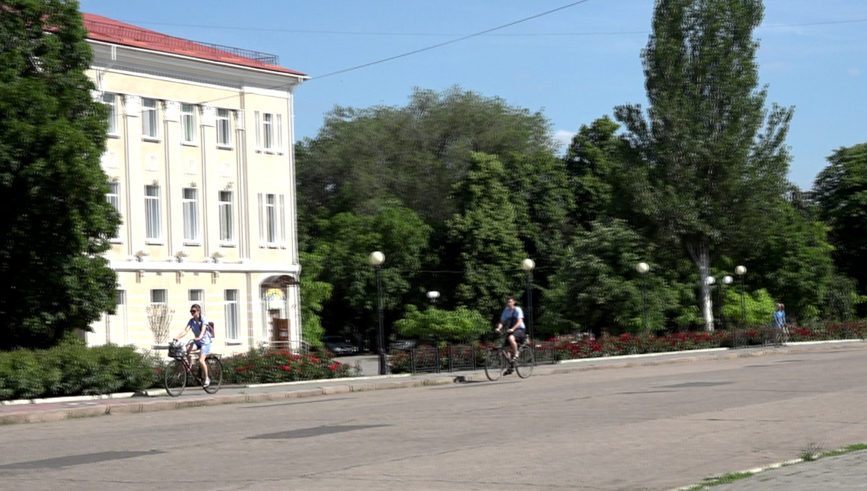 Młodzi ludzie jeżdżący po Bachmucie rowerami w lipcu. 