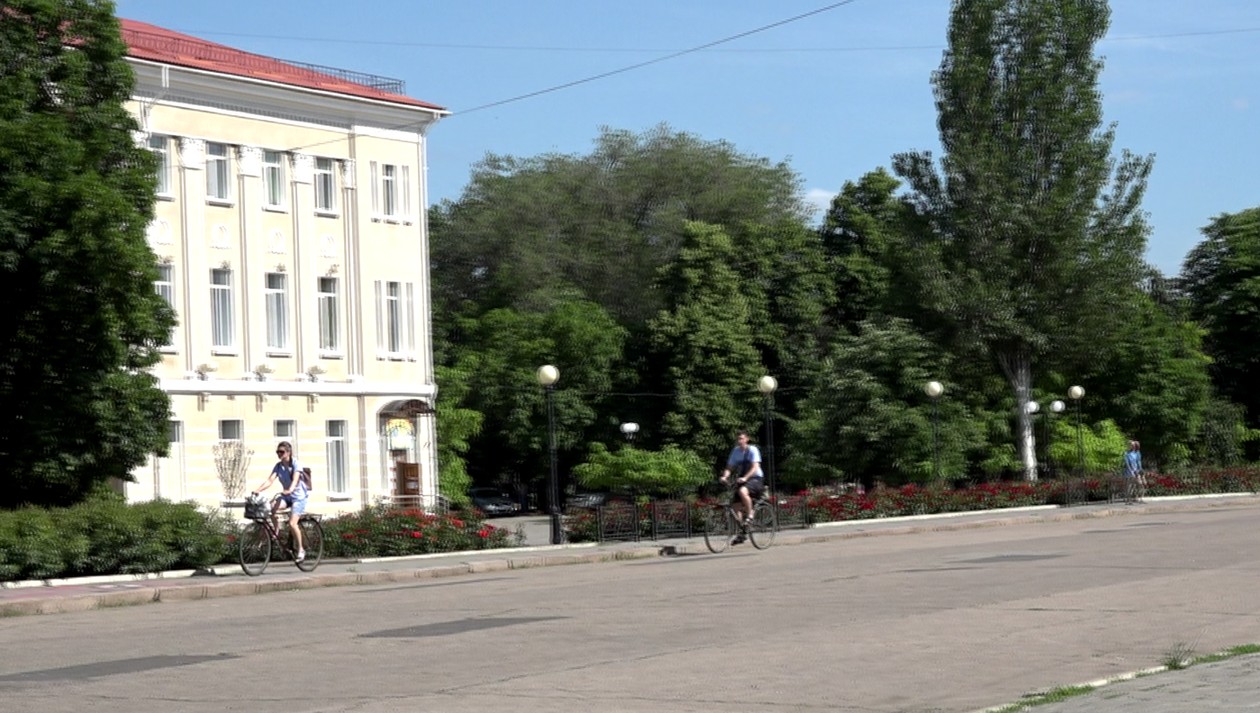 Młodzi ludzie jeżdżący po Bachmucie rowerami w lipcu. 