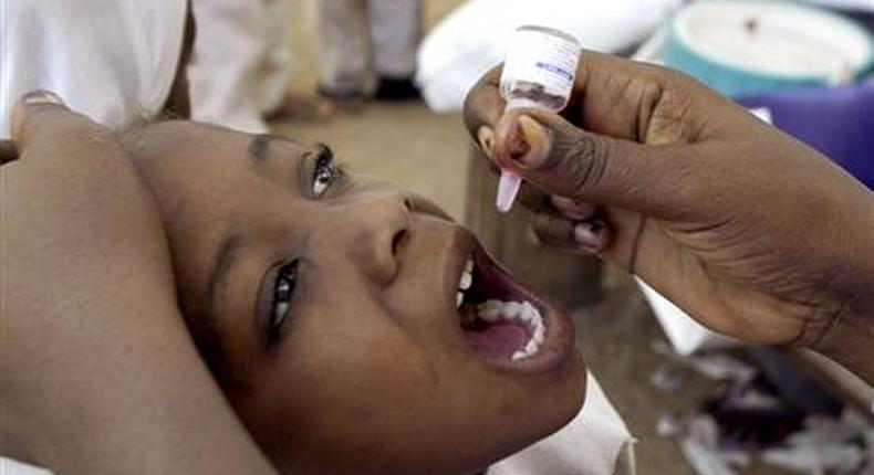 A health worker gives a child an oral polio vaccine in Kano, Nigeria. 