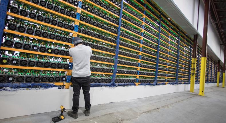 A worker checks the fans on miners, at the cryptocurrency farming operation, Bitfarms, in Farnham, Quebec, Canada.

