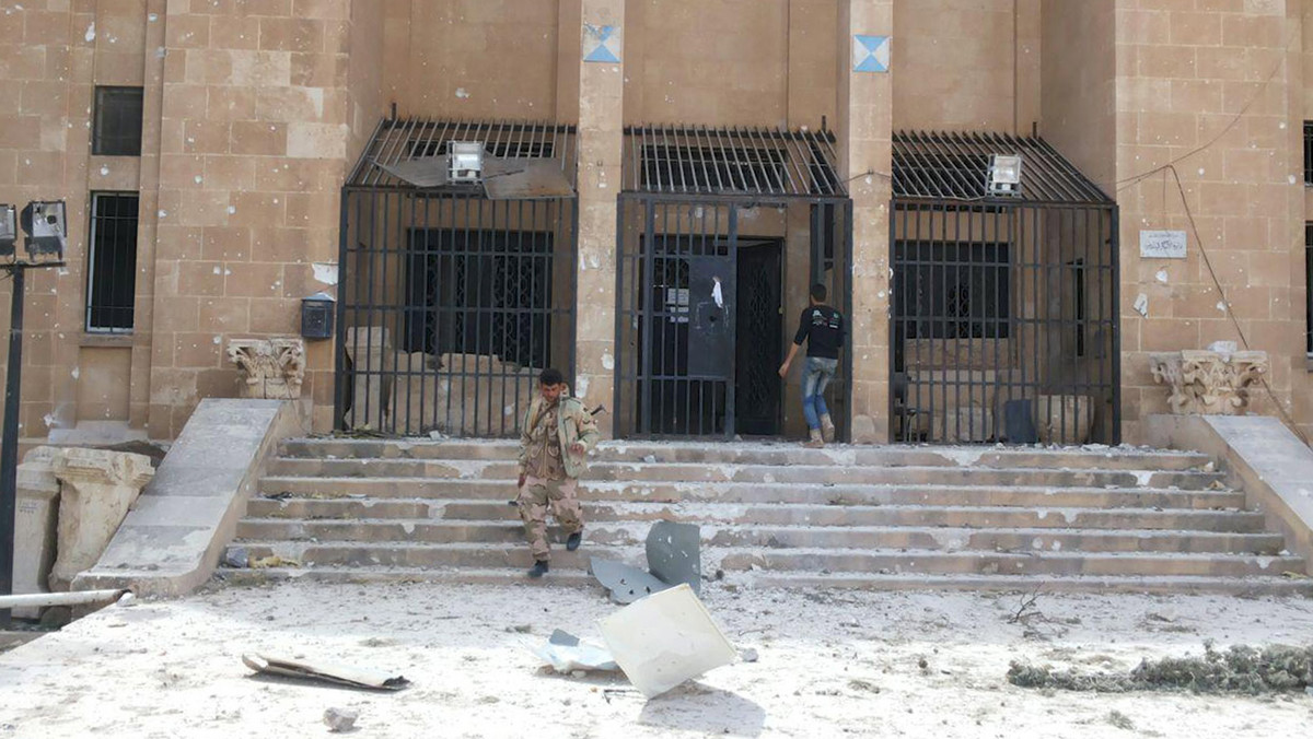A member of forces loyal to Assad walks down the stairs of the museum of the historic city of Palmyra, after government forces recaptured the city