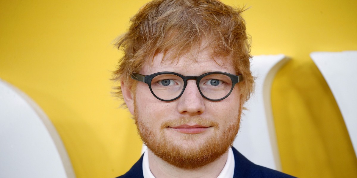 Ed Sheeran wręcza swoim przyjaciołom nietypowe figurki. Żartobliwy gest.