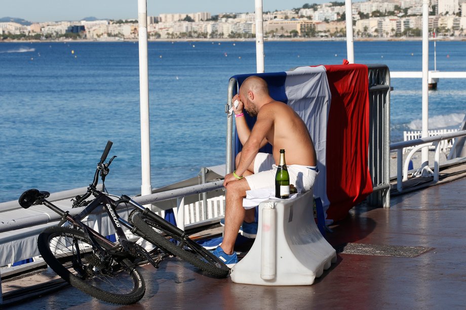 A man near a French flag along the beachfront the day after the truck attack in Nice.