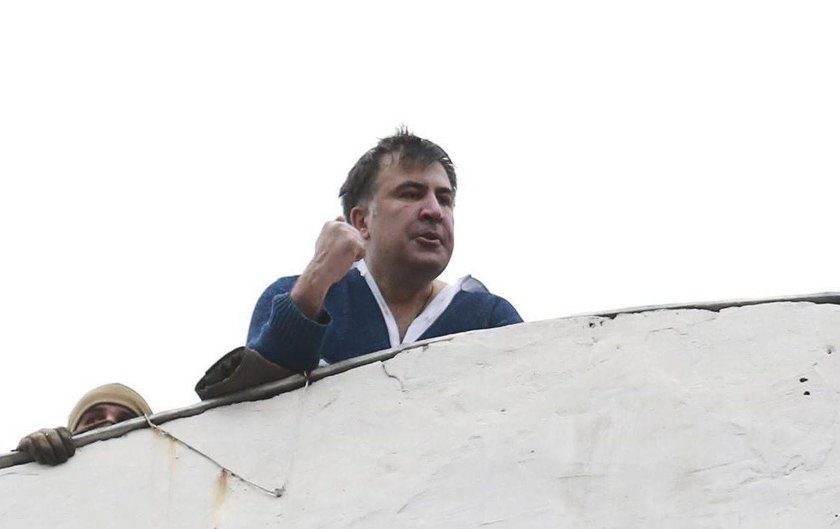 Supporters of Georgian former President Mikheil Saakashvili break a window a police car carrying Saa