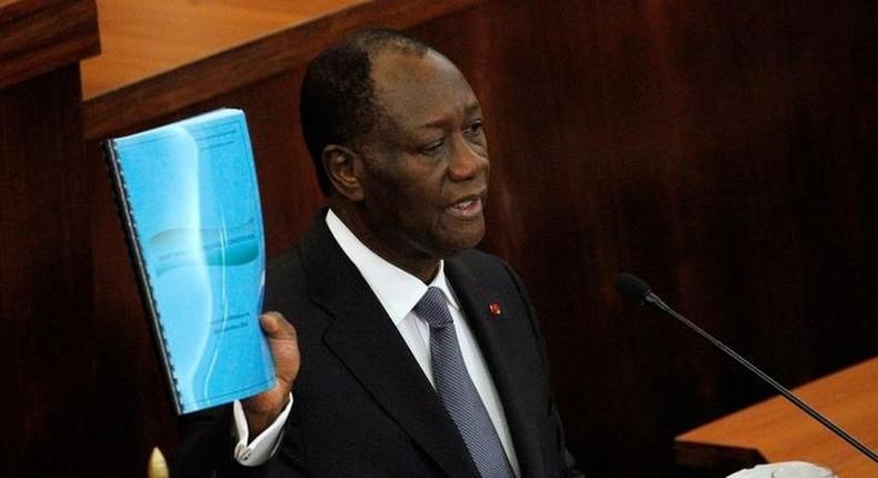 Ivory Coast's President Alassane Ouattara holds the new constitution project document during his speach at the Ivorian parliament in Abidjan October 5, 2016. REUTERS/Luc Gnago