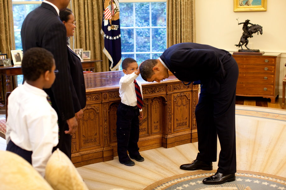 Prezydent Barack Obama pochyla się, by syn członka personelu Białego Domu mógł poklepać go po głowie w 2009 r.