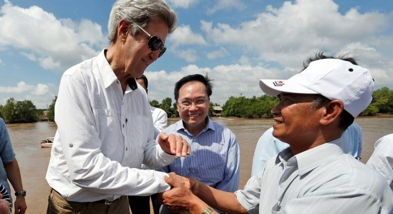 US Secretary of State John Kerry (L) shakes hands with Vo Ban Tam, 70, who was a member of the former Viet Cong guerrilla and who took part in the attack on Kerry's Swift Boat on February 28, 1969