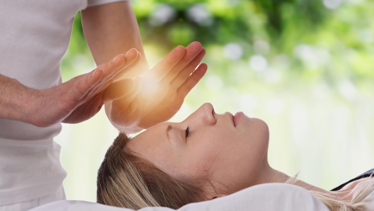 Woman having reiki healing treatment , alternative medicine concept.