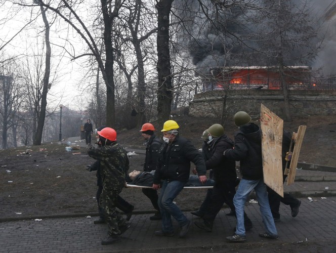 Działacze opozycji niosą rannego po starciach
